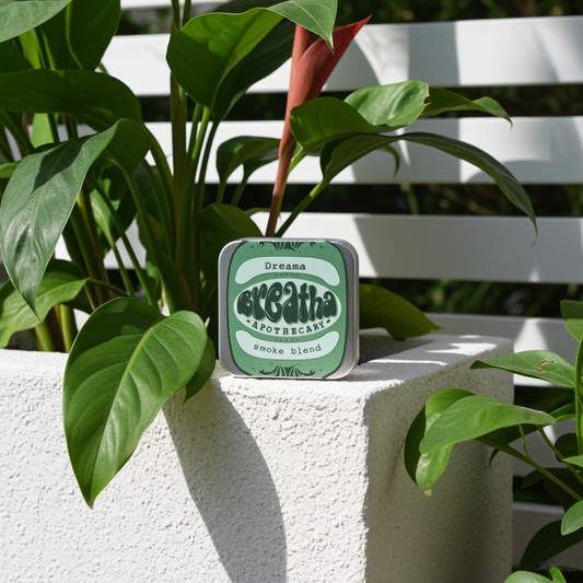 Tin box with 'Breatha' branding on a white surface with green leaves.
